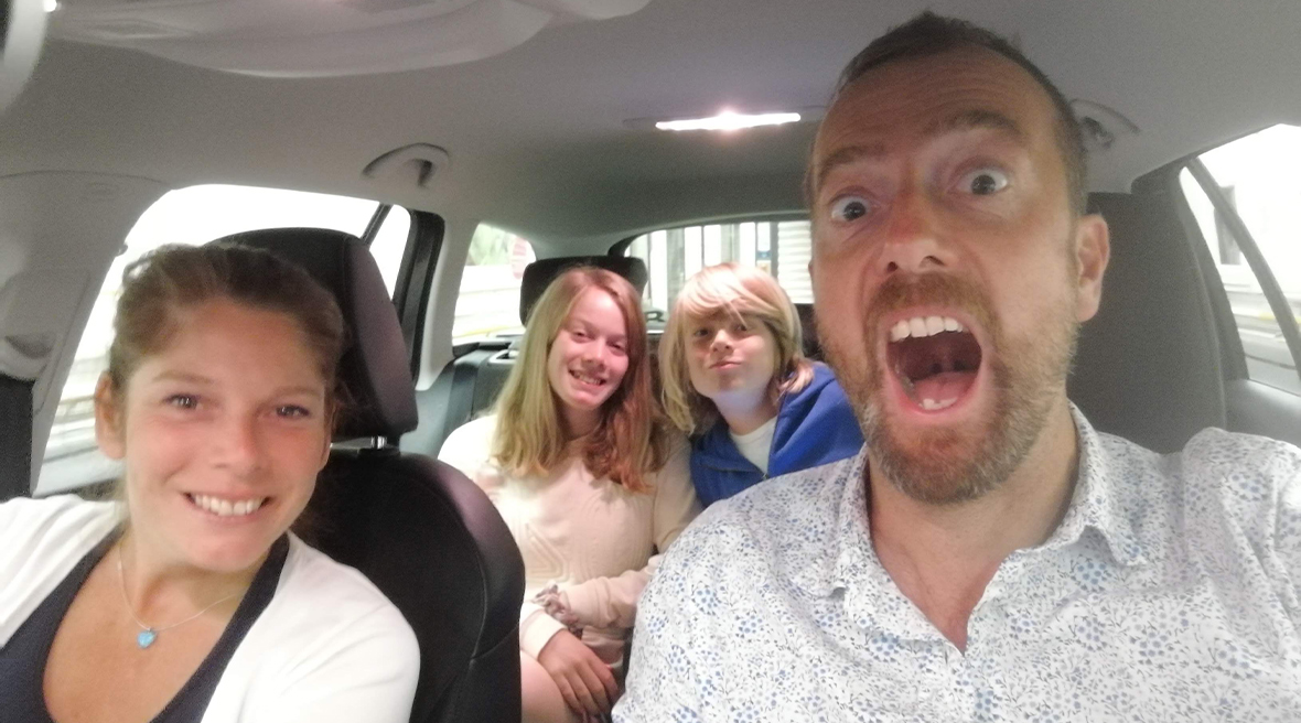 The Trueman family pose for a selfie in their car